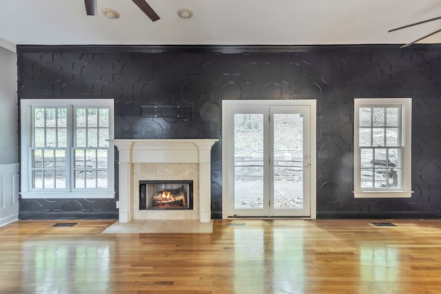 unfurnished living room with ceiling fan, light hardwood / wood-style floors, and a healthy amount of sunlight