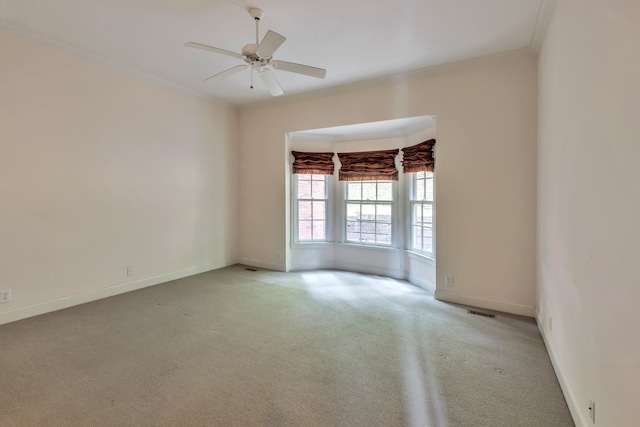 carpeted empty room featuring ceiling fan and ornamental molding