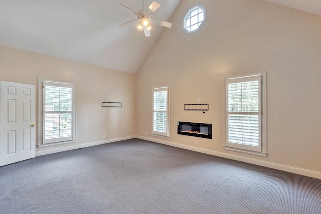 unfurnished living room featuring plenty of natural light, high vaulted ceiling, carpet, and ceiling fan