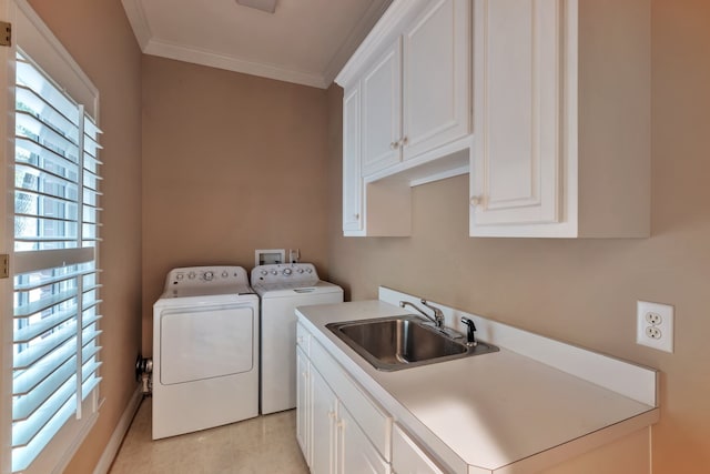 laundry area featuring crown molding, independent washer and dryer, sink, and cabinets