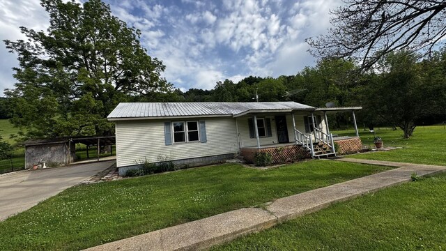 315 Loyd Rd, Pulaski, TN 38478 - view of front of home featuring covered porch, a front yard, concrete driveway, a metal roof, and a carport