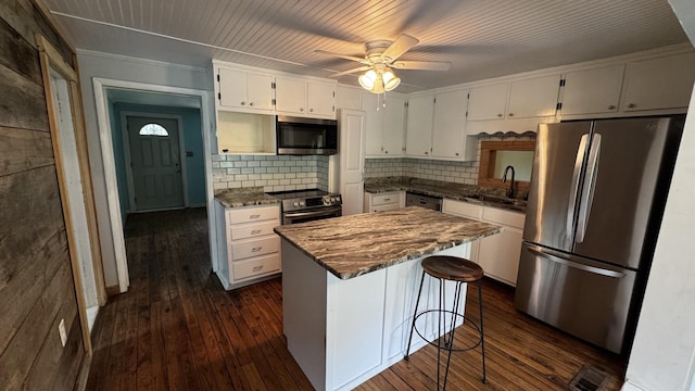 315 Loyd Rd, Pulaski, TN 38478 - kitchen with stainless steel appliances, white cabinetry, dark wood-style flooring, decorative backsplash, and ornamental molding