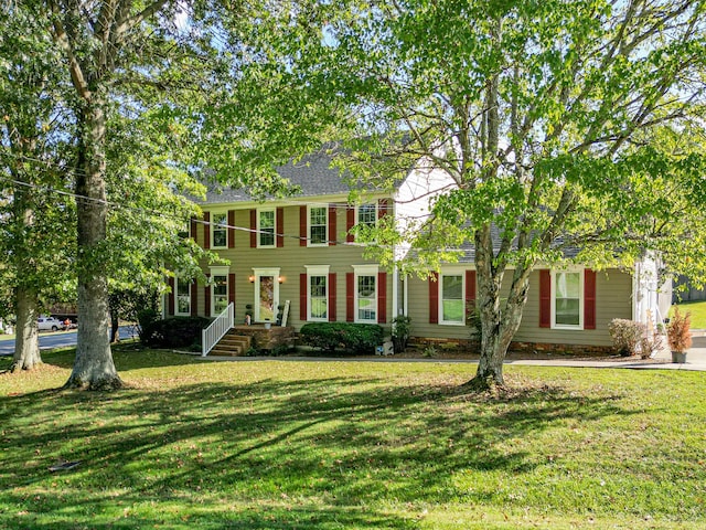 colonial-style house featuring a front yard