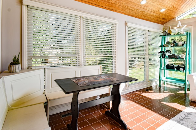 tiled dining room with wood ceiling and vaulted ceiling