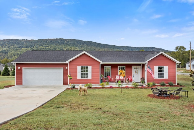 single story home featuring a mountain view, a garage, and a front lawn