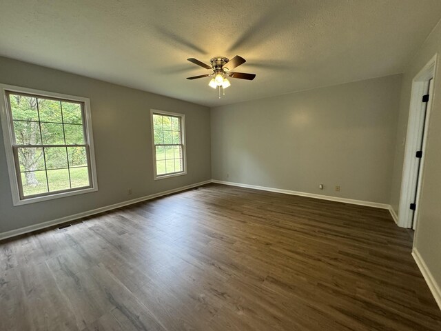 empty room featuring ceiling fan, dark hardwood / wood-style flooring, and a textured ceiling