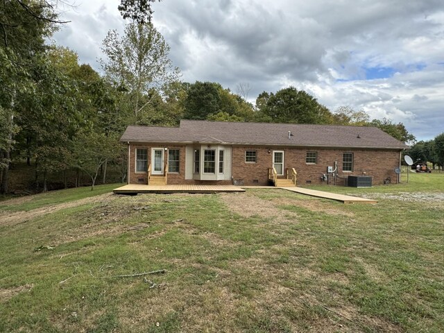 ranch-style home featuring a wooden deck, central AC, and a front yard