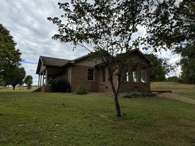 view of side of property with a lawn