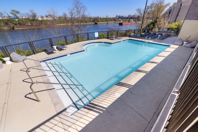 view of swimming pool featuring a water view and a patio