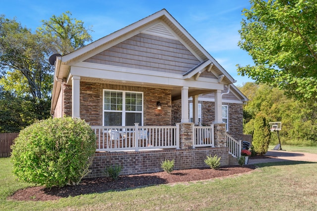 craftsman-style house featuring a porch and a front lawn