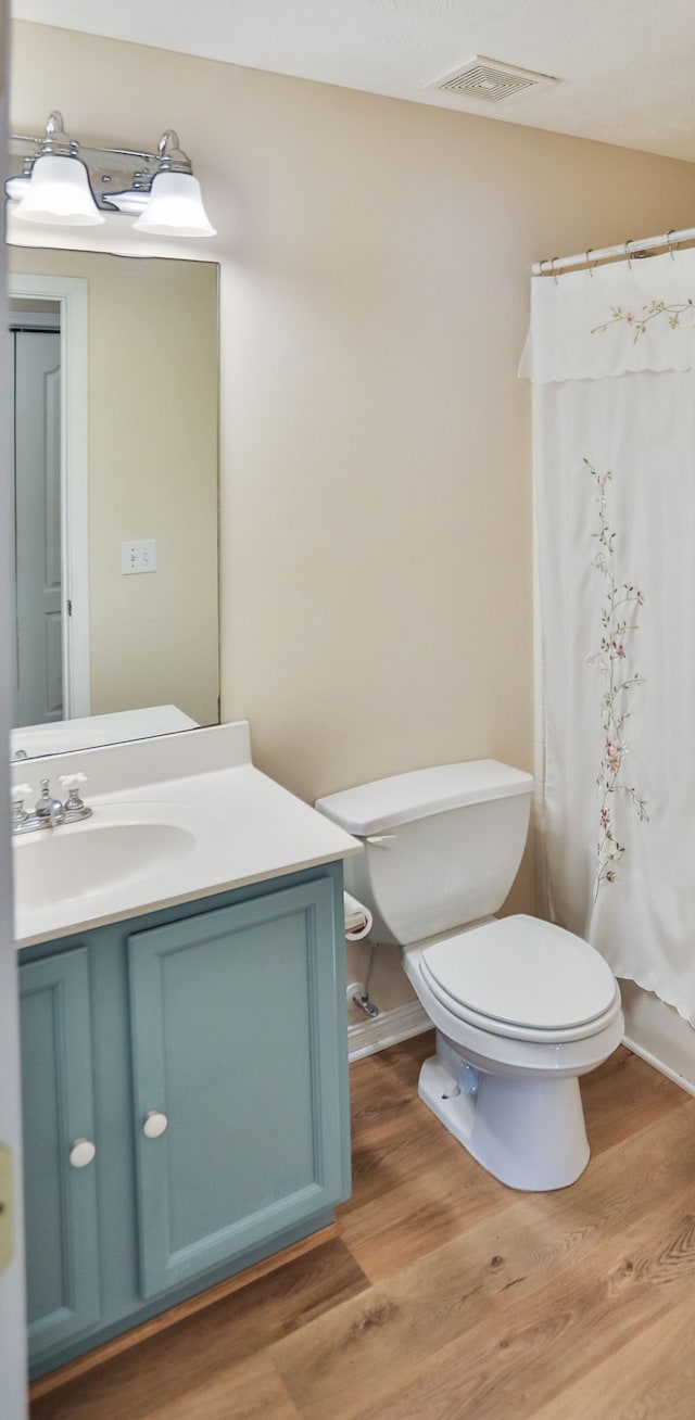 bathroom featuring a shower with shower curtain, vanity, toilet, and wood-type flooring