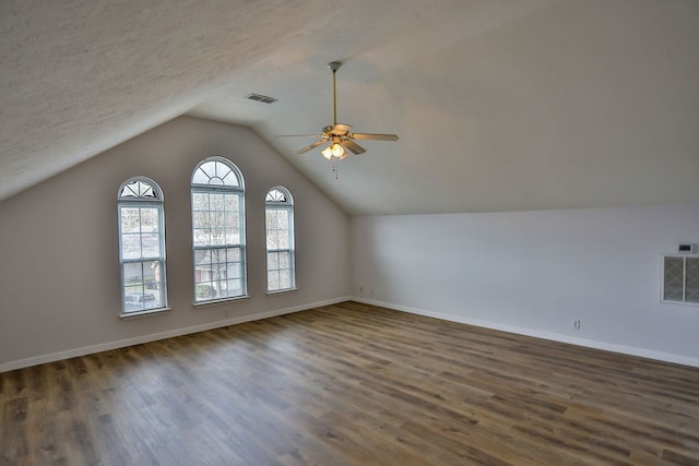 bonus room featuring a textured ceiling, dark wood-type flooring, ceiling fan, and lofted ceiling