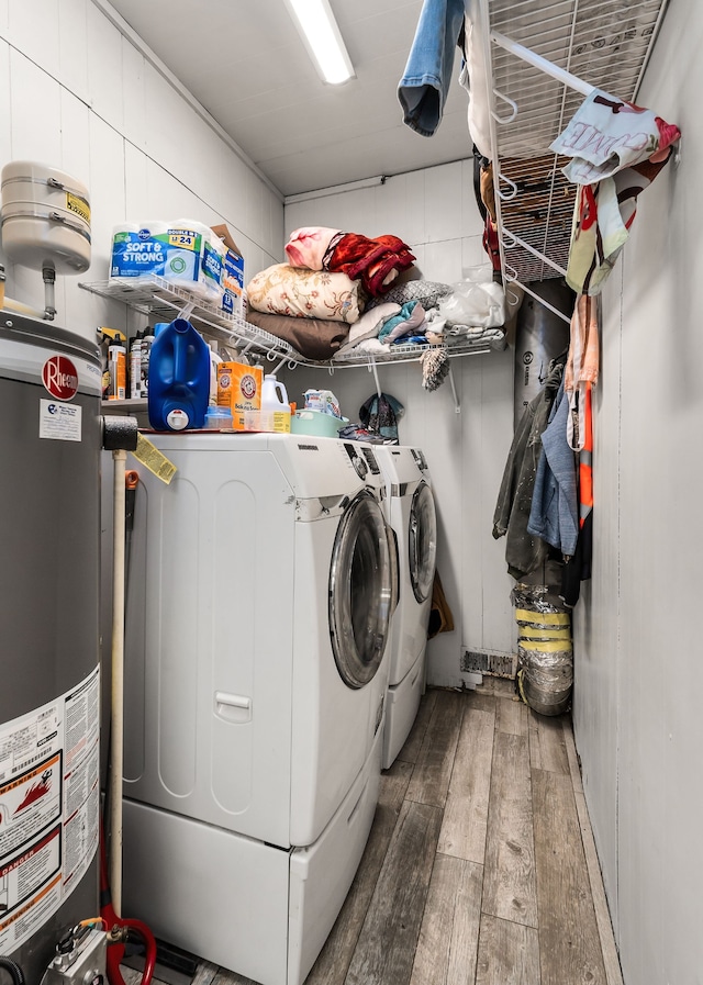 washroom with wood-type flooring, water heater, and washer and clothes dryer