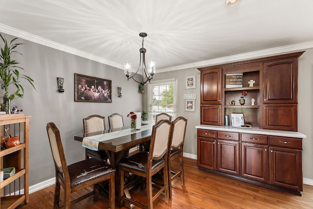 dining area featuring crown molding, light hardwood / wood-style flooring, and a chandelier