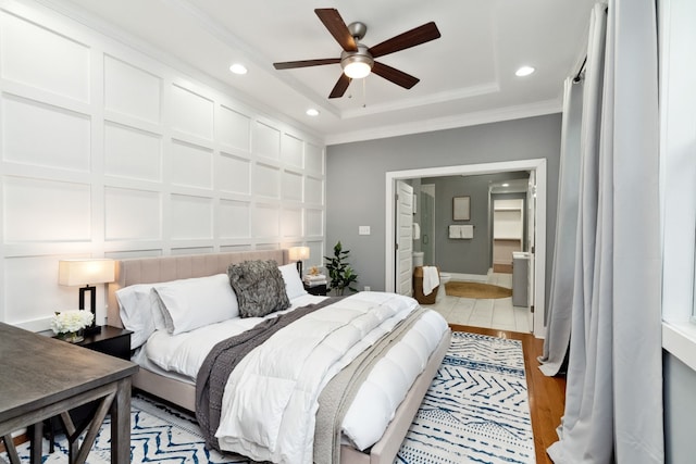 bedroom with a raised ceiling, ceiling fan, light hardwood / wood-style flooring, and ornamental molding