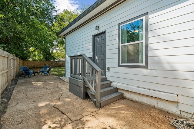 view of exterior entry with a patio area