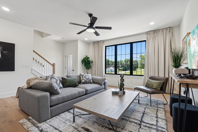 living room featuring light wood-type flooring and ceiling fan