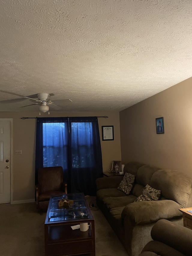 living room featuring a textured ceiling, dark colored carpet, and ceiling fan