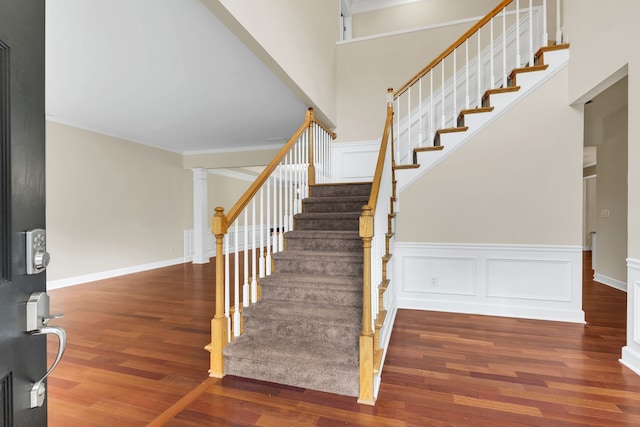 stairs featuring a high ceiling and hardwood / wood-style flooring