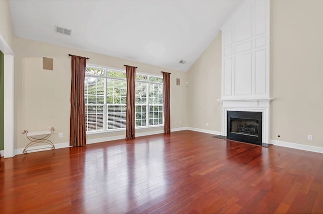 unfurnished living room with a fireplace, dark hardwood / wood-style floors, and vaulted ceiling