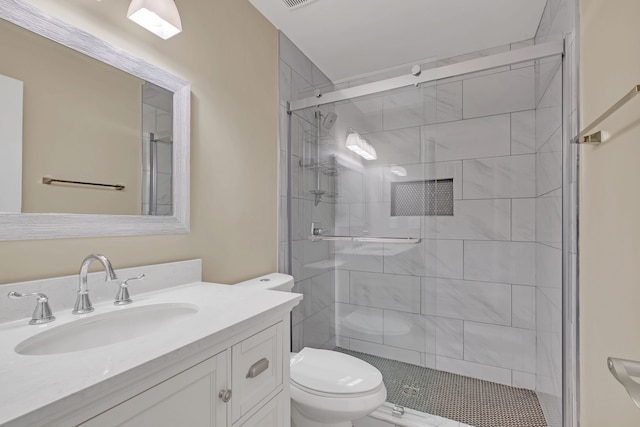 bathroom featuring vanity, toilet, and a shower with door