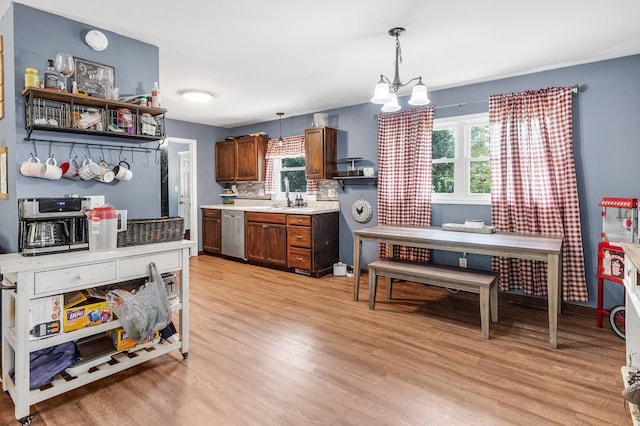 kitchen featuring dishwasher, light wood-type flooring, a wealth of natural light, and decorative light fixtures