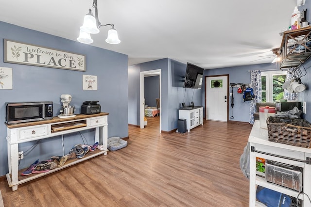 interior space featuring ceiling fan with notable chandelier and hardwood / wood-style flooring