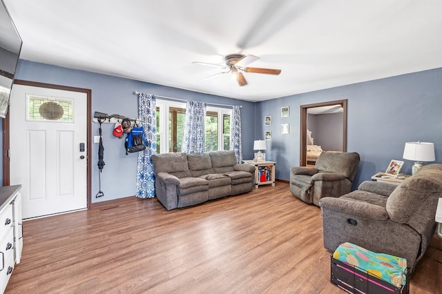 living room featuring light wood-type flooring and ceiling fan