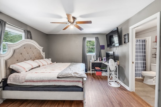 bedroom with ensuite bath, hardwood / wood-style flooring, and ceiling fan