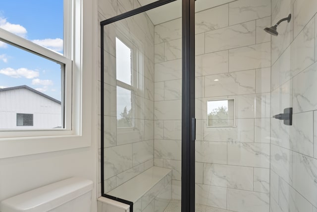 bathroom featuring walk in shower and toilet