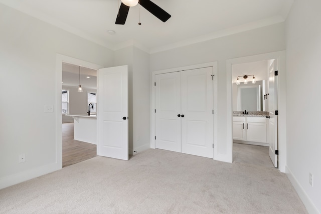 unfurnished bedroom featuring ceiling fan, ornamental molding, a closet, and ensuite bathroom