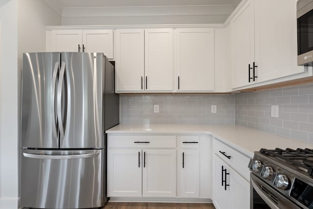 kitchen featuring light hardwood / wood-style flooring, white cabinetry, appliances with stainless steel finishes, and tasteful backsplash