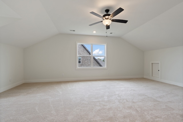 additional living space featuring ceiling fan, light carpet, and vaulted ceiling