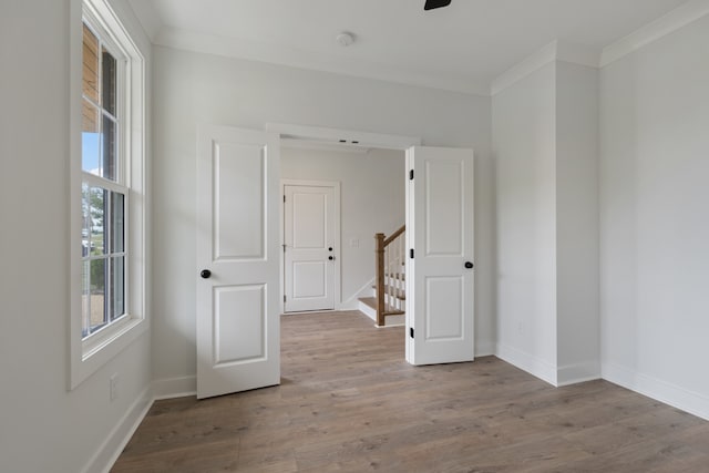 empty room with ornamental molding and hardwood / wood-style floors