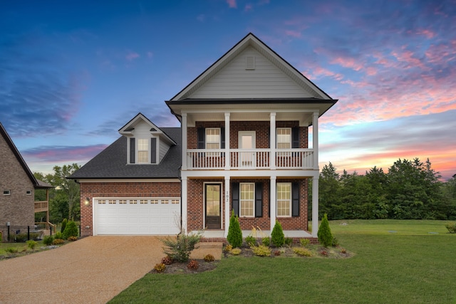 view of front facade featuring a balcony, covered porch, a garage, and a yard