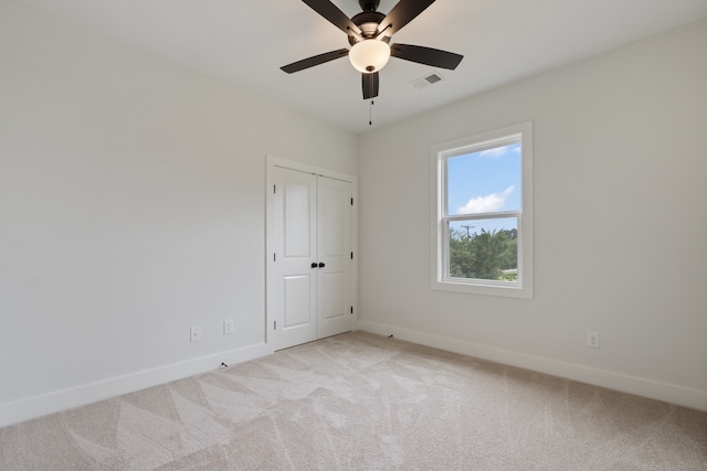 carpeted spare room with ceiling fan