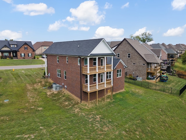 back of house with a balcony and a lawn