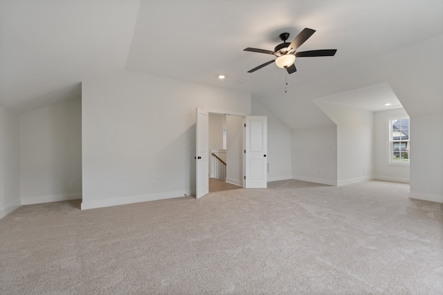 additional living space featuring light carpet, vaulted ceiling, and ceiling fan