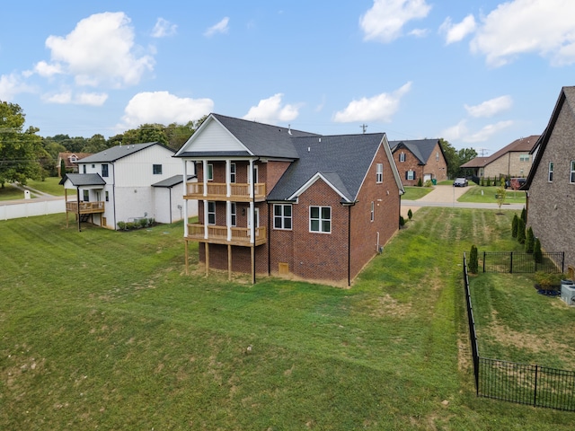 rear view of property featuring a balcony and a yard