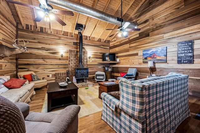 living room with ceiling fan, wood ceiling, light wood-type flooring, and a wood stove