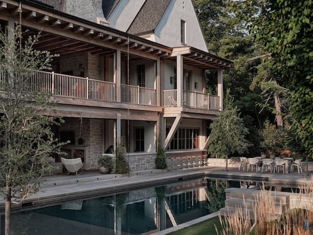 back of house featuring a balcony and a patio area