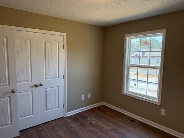 unfurnished room featuring dark hardwood / wood-style floors and a textured ceiling