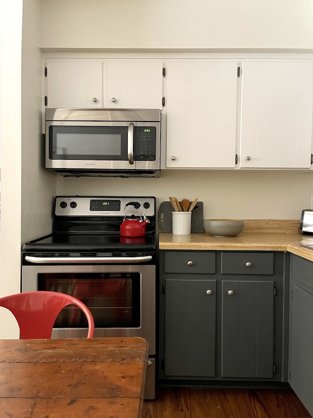 kitchen with gray cabinets, white cabinetry, dark hardwood / wood-style flooring, and stainless steel appliances