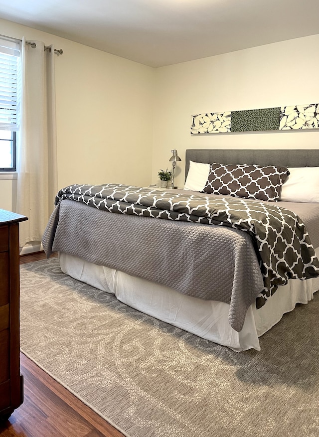 bedroom with dark hardwood / wood-style flooring