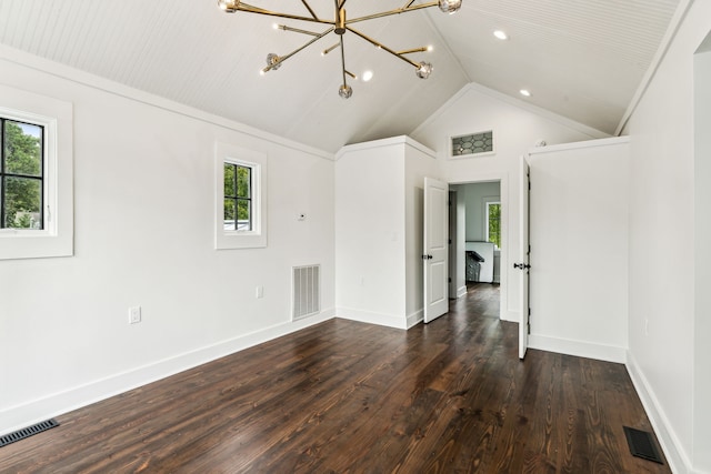 spare room featuring dark hardwood / wood-style flooring, vaulted ceiling, and a notable chandelier