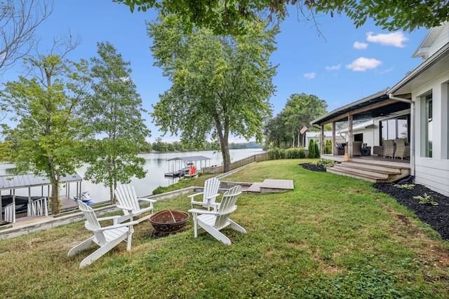 view of yard featuring a deck with water view and an outdoor fire pit