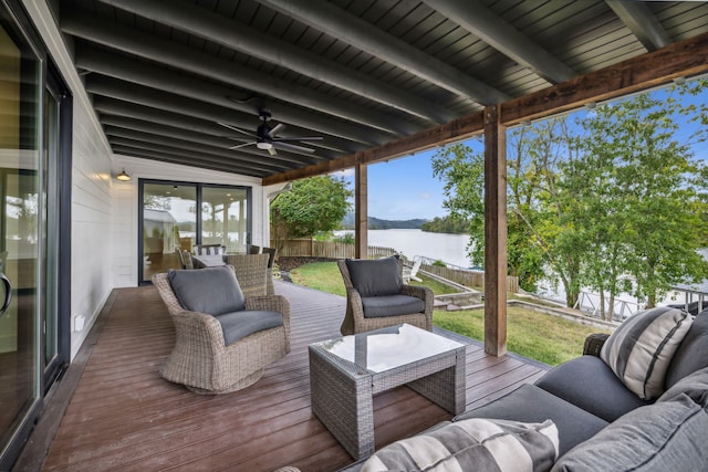 wooden deck featuring outdoor lounge area, a yard, and a water view