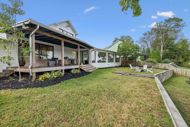 view of yard featuring a sunroom and an outdoor living space with a fire pit