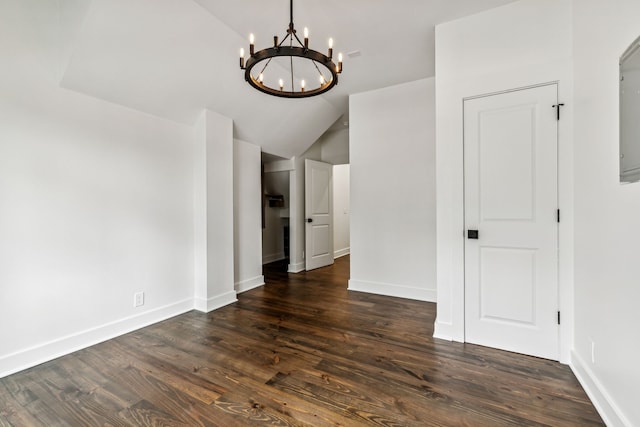 unfurnished room featuring a chandelier, dark hardwood / wood-style flooring, and vaulted ceiling