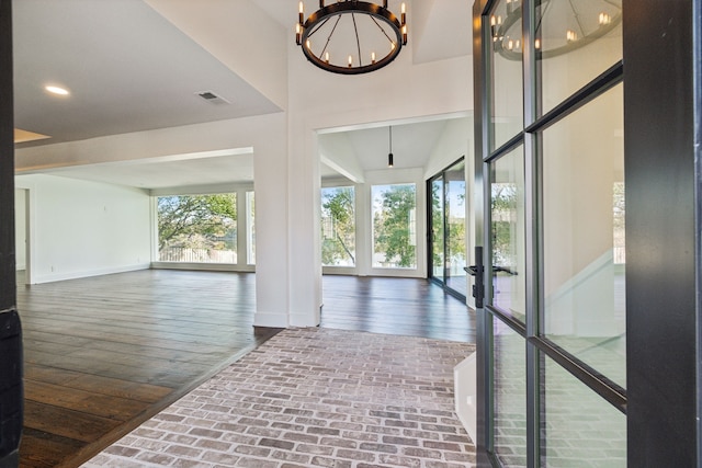 hallway featuring dark hardwood / wood-style flooring, french doors, and a chandelier